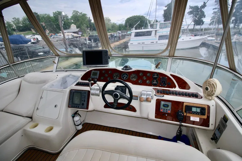 Slide: The Image of Helm of 2001 Maxum 4600 SCB yacht with navigation equipment and luxurious seating. - 14