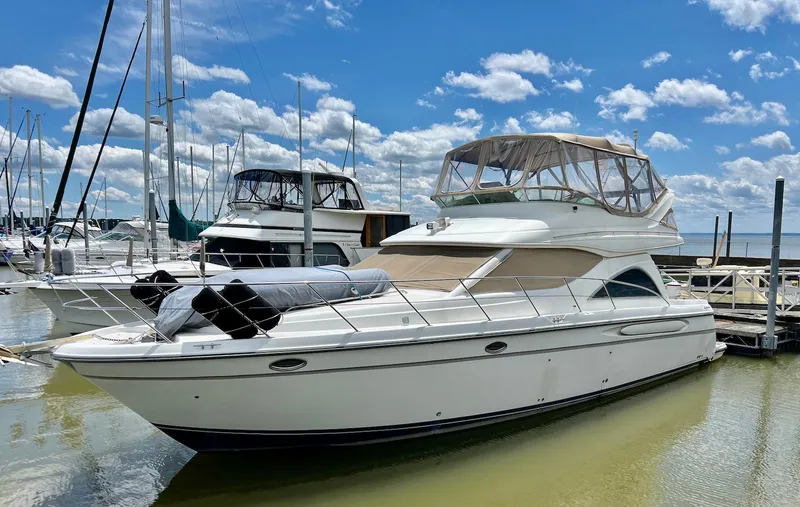 Slide: The Image of 2001 Maxum 4600 SCB yacht docked at marina under blue sky. - 2