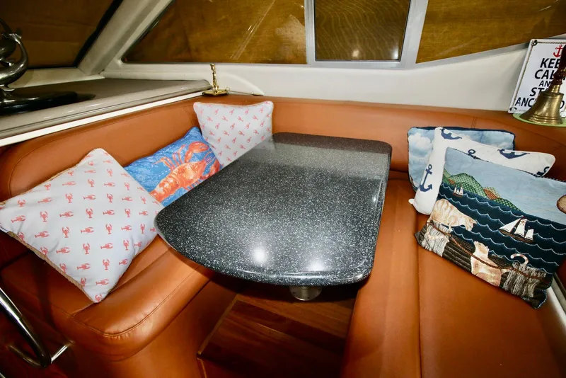Slide: The Image of Cozy seating area on 2001 Maxum 4600 SCB yacht with decorative pillows and sleek table. - 23