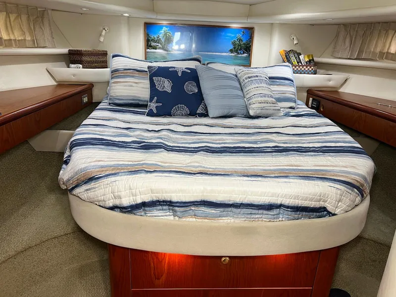 Slide: The Image of Luxurious bedroom interior of 2001 Maxum 4600 SCB yacht with striped bedding and decorative pillows. - 25