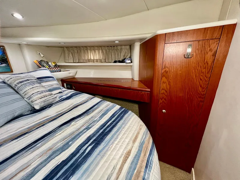 Slide: The Image of Luxurious cabin interior of 2001 Maxum 4600 SCB yacht with striped bedding and wooden cabinetry. - 27