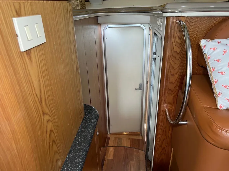 Slide: The Image of Interior of 2001 Maxum 4600 SCB yacht, featuring wooden paneling and a narrow hallway. - 28