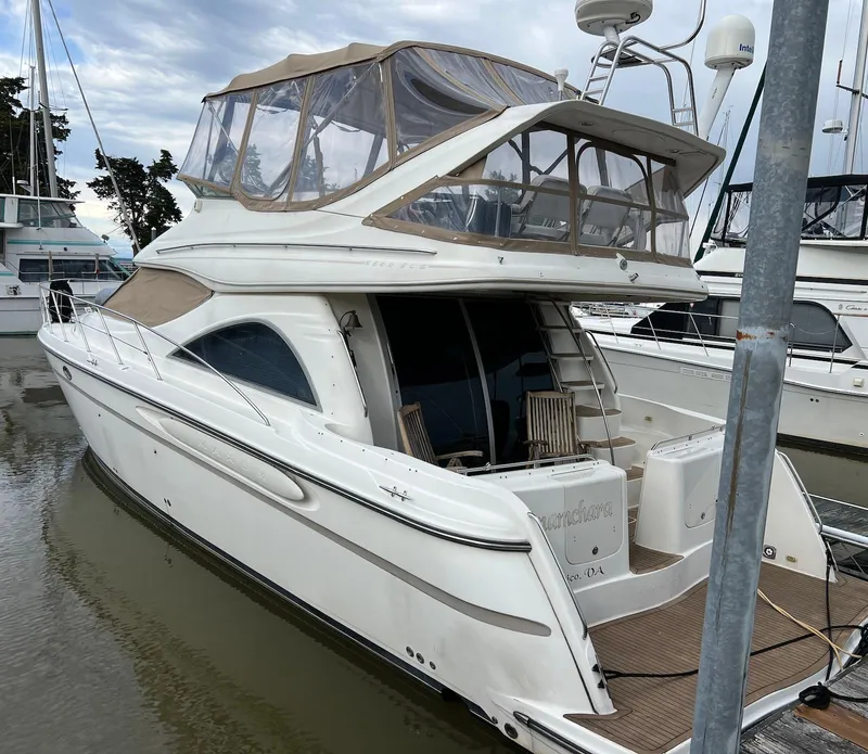 Slide: The Image of 2001 Maxum 4600 SCB yacht docked at marina, featuring upper deck and sleek design. - 3