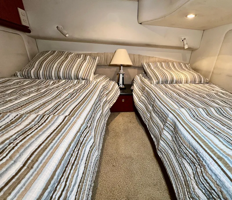 Slide: The Image of Twin beds in a 2001 Maxum 4600 SCB yacht cabin with striped bedding. - 32