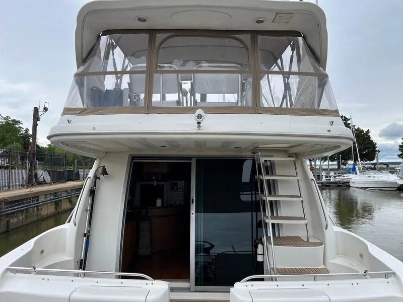 Slide: The Image of 2001 Maxum 4600 SCB yacht with upper deck, docked at marina. - 6