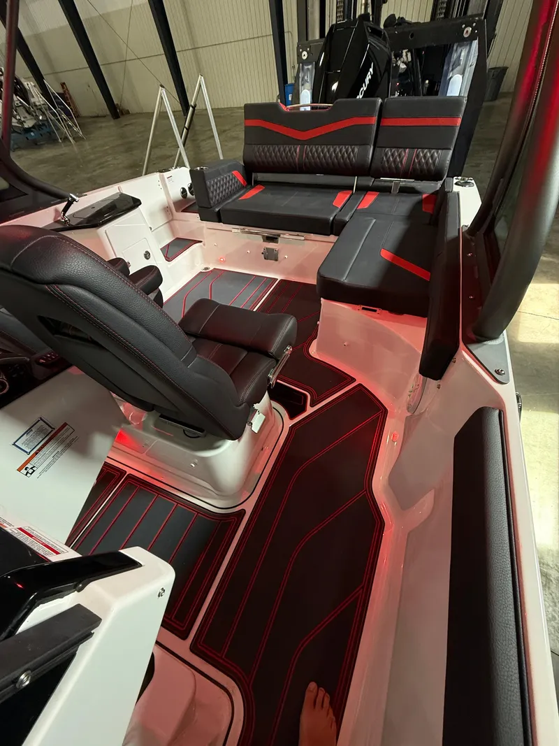 Slide: The Image of 2025 Monterey Elite 27 OB boat interior with sleek black and red seating and modern design. - 14