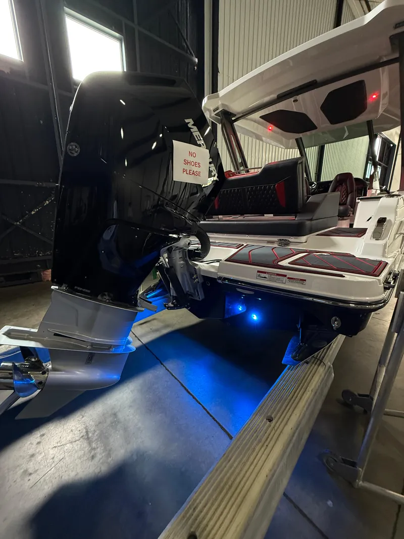 Slide: The Image of 2025 Monterey Elite 27 OB boat with illuminated deck and powerful outboard motor. - 15