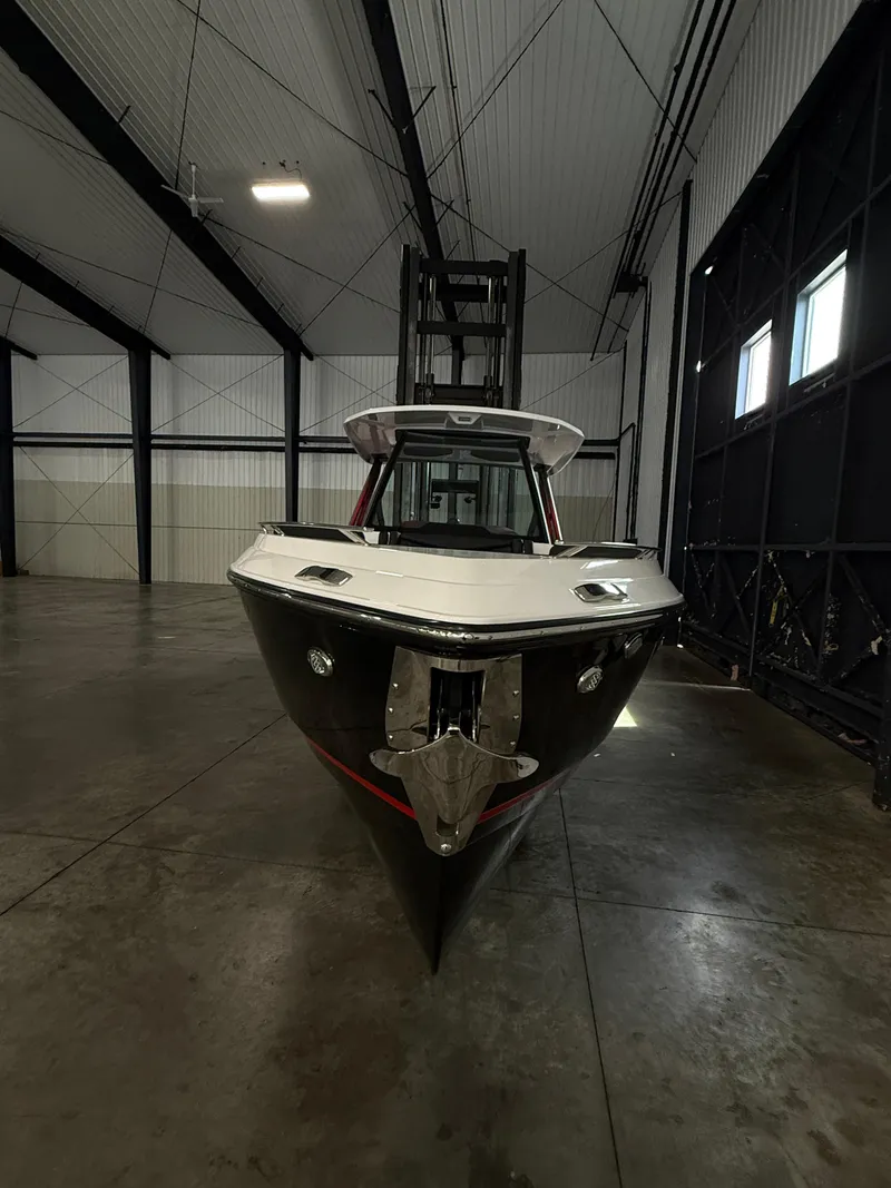 Slide: The Image of 2025 Monterey Elite 27 OB boat in a spacious indoor storage facility. - 16