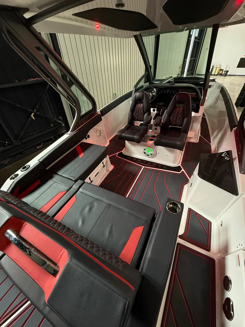 Slide: The Image of 2025 Monterey Elite 27 OB boat interior with black and red seating, modern design. - 7