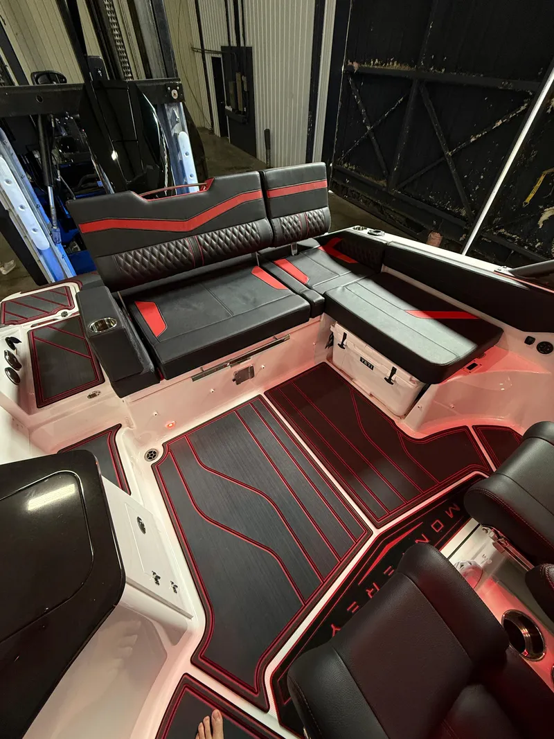 Slide: The Image of 2025 Monterey Elite 27 OB boat interior with sleek black and red seating design. - 8