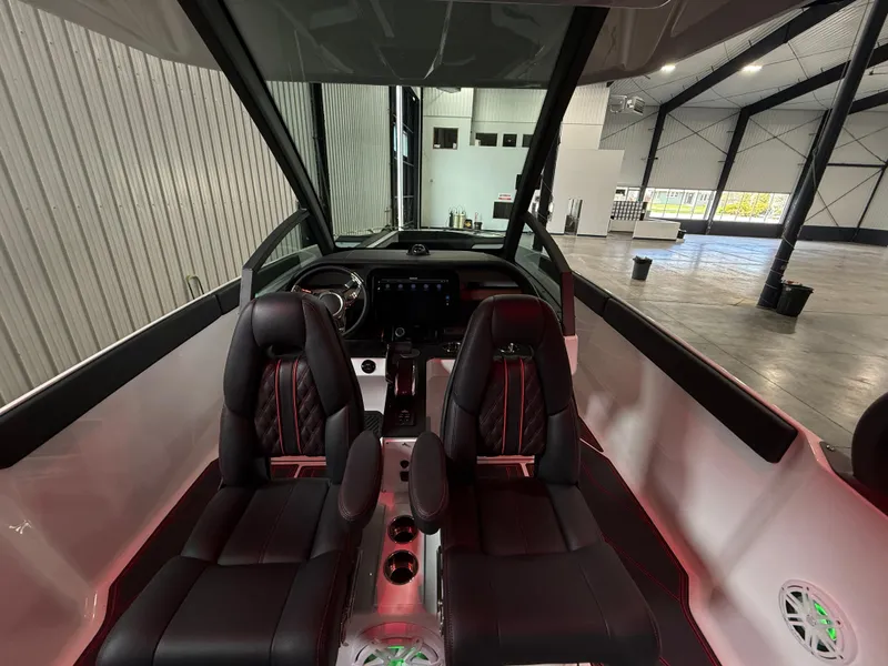 Slide: The Image of Interior of 2025 Monterey Elite 27 OB boat with black leather seats and modern dashboard. - 9