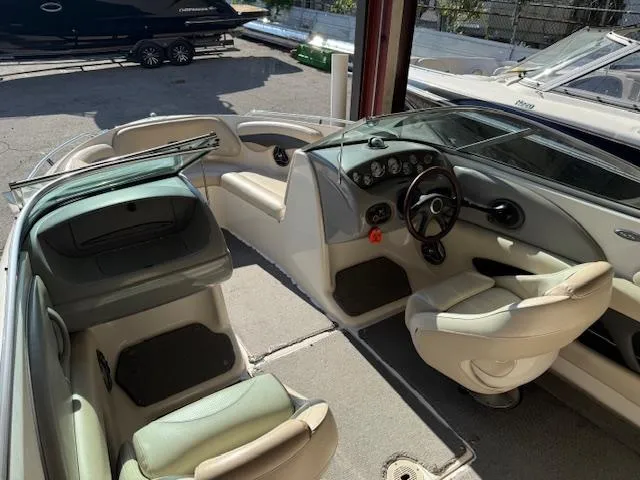 Slide: The Image of 2004 Chaparral 210 SSi boat interior with beige seating and dashboard controls. - 13