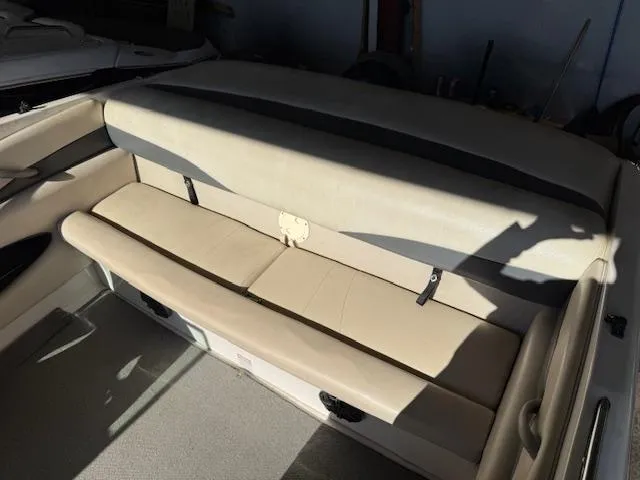 Slide: The Image of 2004 Chaparral 210 SSi boat interior with beige seating and storage compartments. - 15