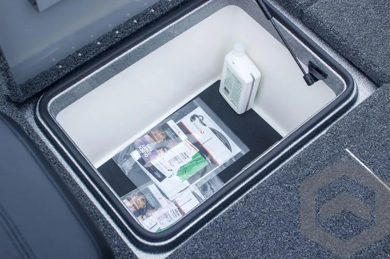 Slide: The Image of Storage compartment in 2025 Caymas CX 21 PRO boat, containing fishing gear and a bottle. - 47