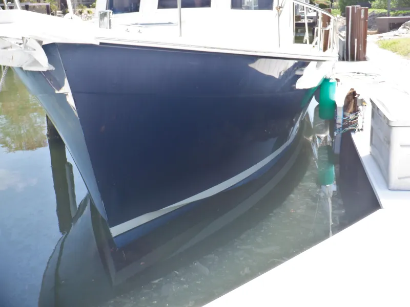 Slide: The Image of 2006 Mainship 34 Trawler docked, reflecting on calm water. - 10