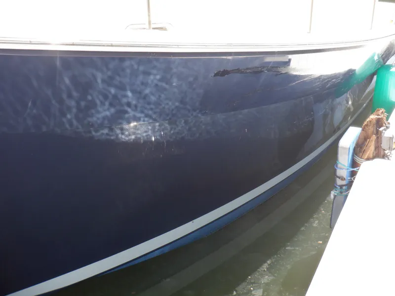 Slide: The Image of 2006 Mainship 34 Trawler, blue hull, docked in sunlight. - 11