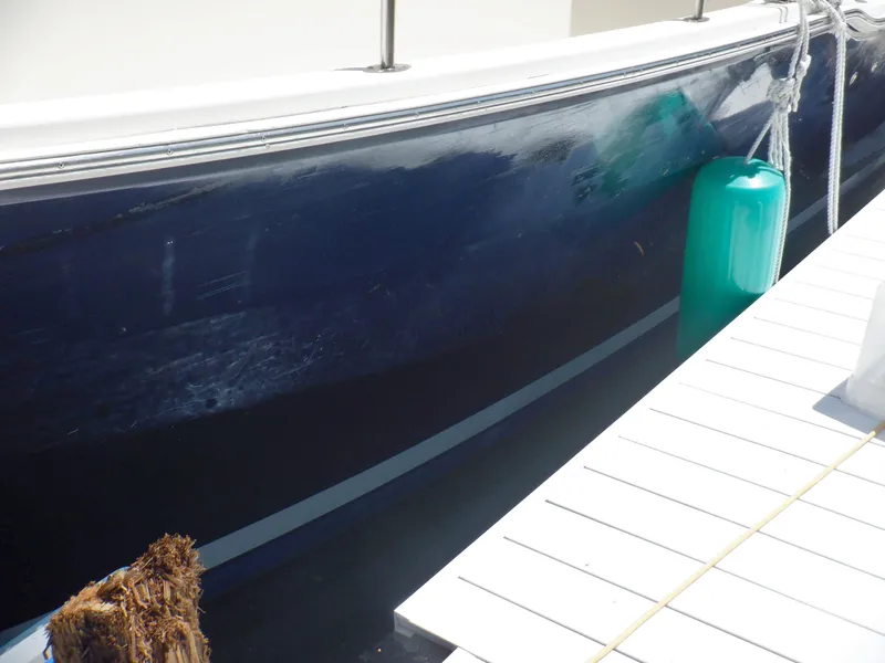 Slide: The Image of 2006 Mainship 34 Trawler docked with blue hull and green fender. - 12