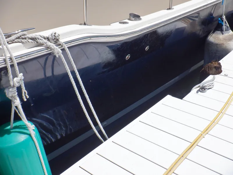 Slide: The Image of 2006 Mainship 34 Trawler docked, showing hull and mooring lines. - 13