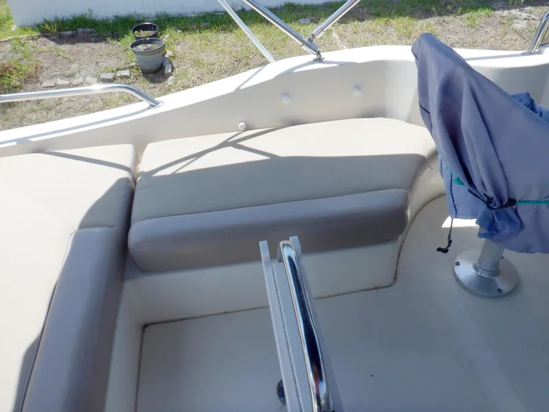 Slide: The Image of 2006 Mainship 34 Trawler interior seating area with covered chair and railing. - 27