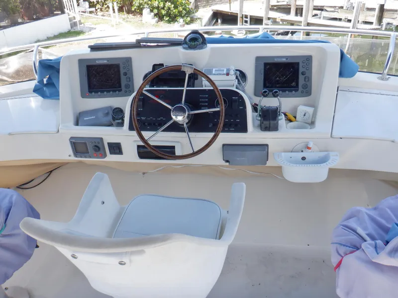 Slide: The Image of 2006 Mainship 34 Trawler helm with steering wheel, navigation screens, and controls. - 30