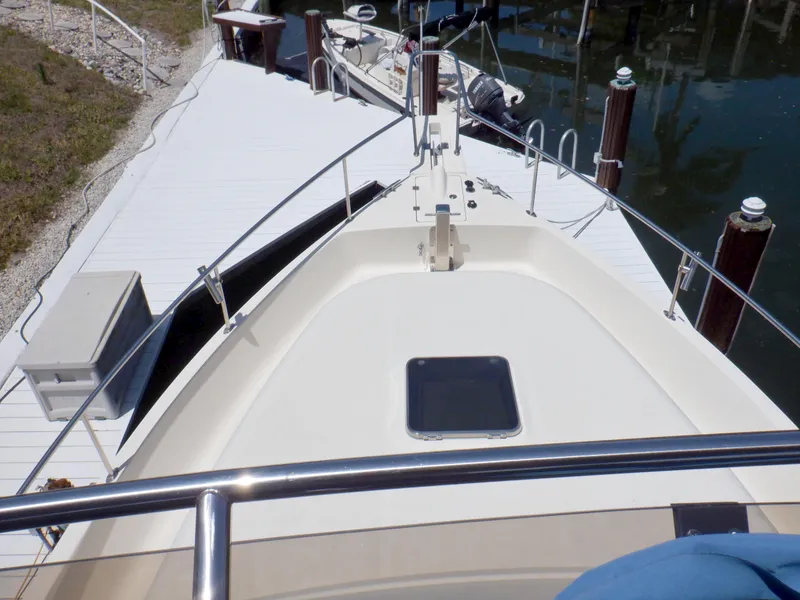 Slide: The Image of 2006 Mainship 34 Trawler docked, showing bow deck and railing. - 39
