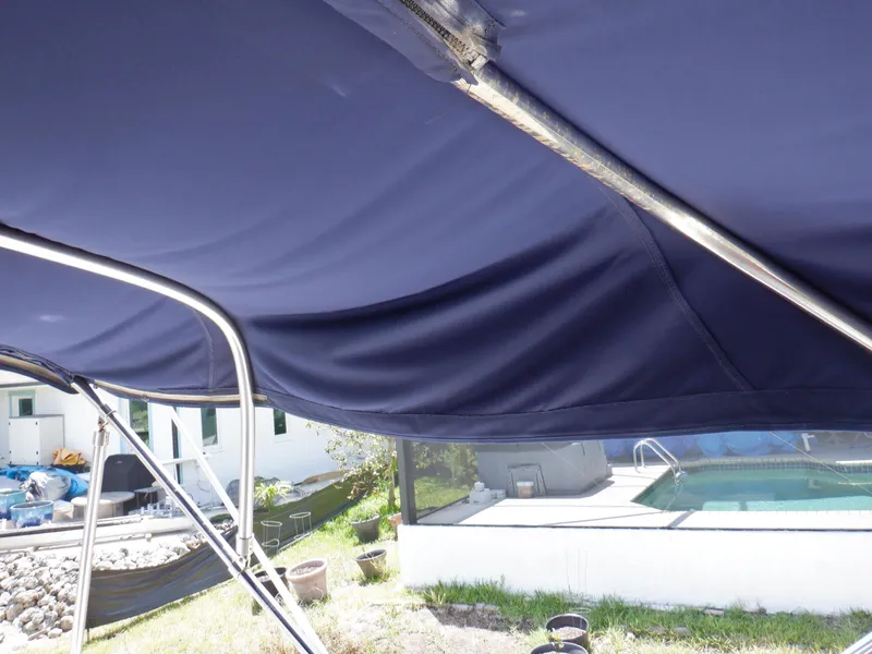 Slide: The Image of Blue canopy of a 2006 Mainship 34 Trawler near a poolside. - 41