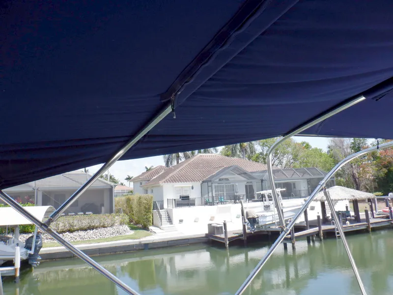 Slide: The Image of 2006 Mainship 34 Trawler view from under canopy, overlooking waterfront homes and docks. - 42
