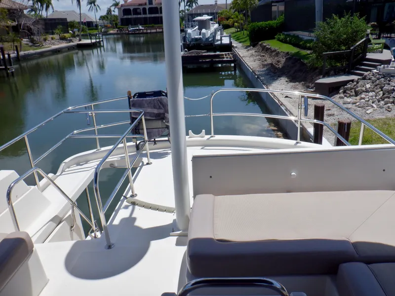 Slide: The Image of 2006 Mainship 34 Trawler on a serene canal, featuring spacious deck and comfortable seating. - 43