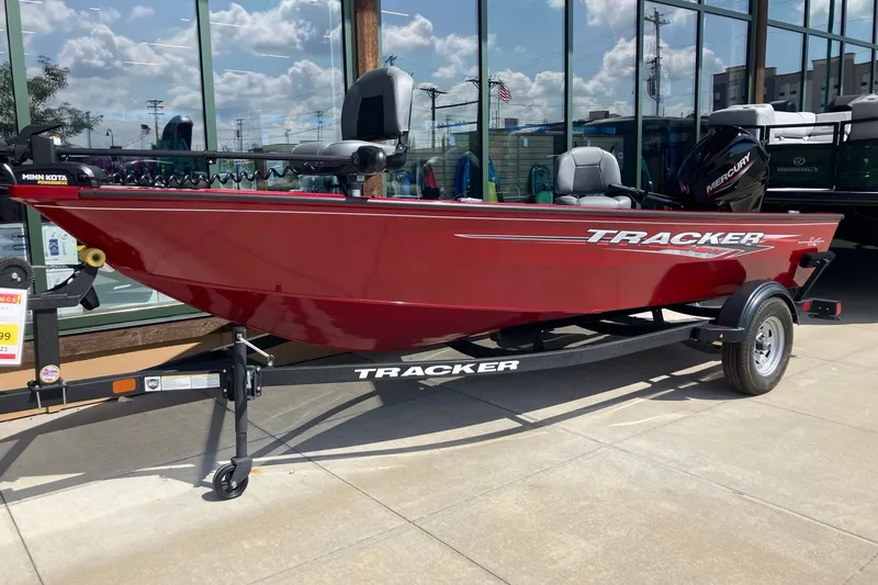 The Image of 2025 Tracker Super Guide V-16 T boat in red on display outside a showroom. - 0
