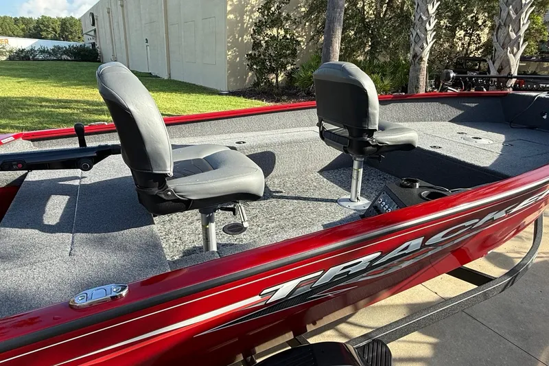 Slide: The Image of 2025 Tracker Super Guide V-16 T boat with two swivel seats, red exterior, and gray interior. - 3