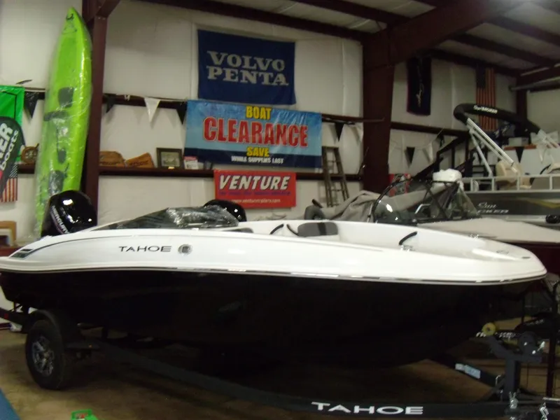 The Image of 2025 Tahoe T18 boat displayed in showroom with clearance sale banners. - 0