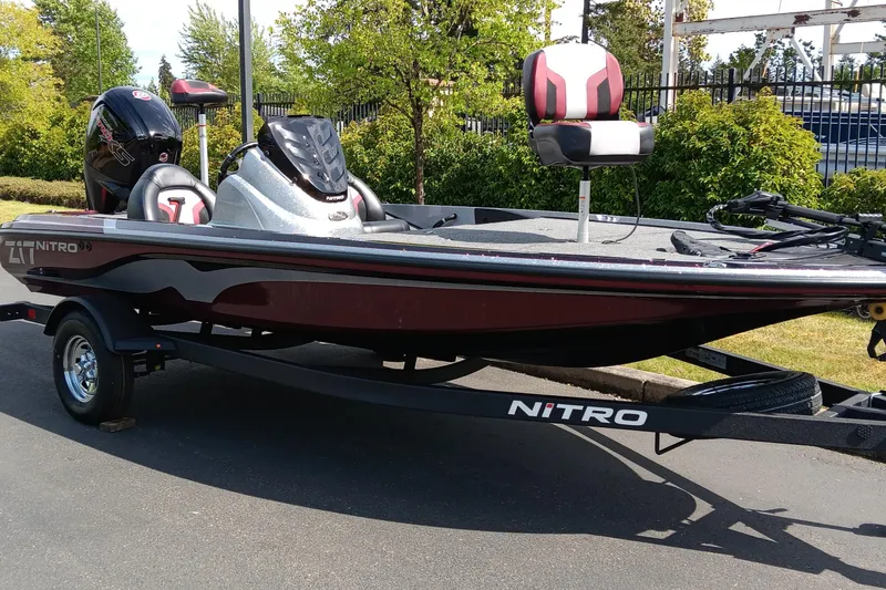 Slide: The Image of 2025 Nitro Z17 boat on trailer, sleek design, red and black color scheme, parked outdoors. - 1