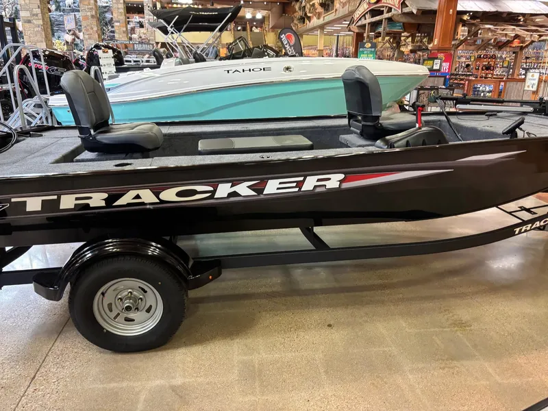 The Image of 2025 Tracker Panfish 17 boat on trailer, parked outdoors with trees in background. - 0