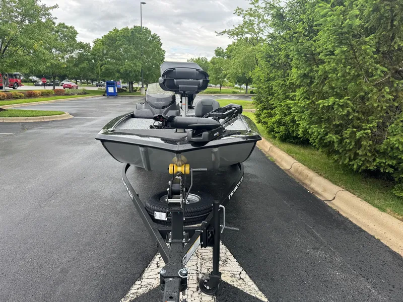 Slide: The Image of 2025 Tracker Pro 170 boat on trailer in parking lot, surrounded by greenery. - 5
