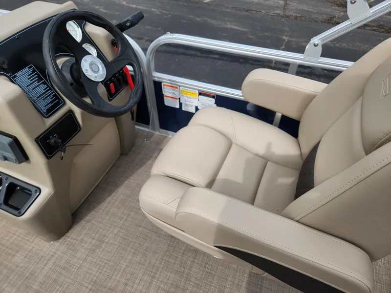 Slide: The Image of 2025 Sun Tracker Bass Buggy 18 DLX boat interior with steering wheel and beige captain's chair. - 3