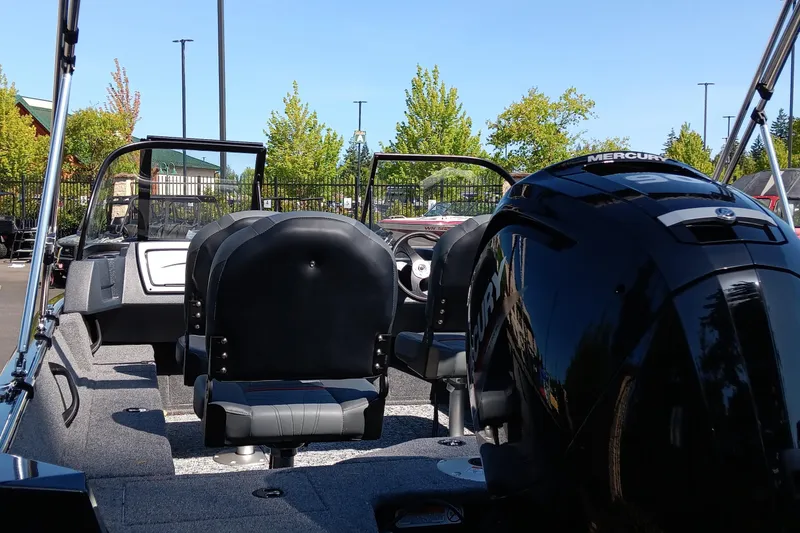 Slide: The Image of 2025 Tracker Pro Guide V-16 WT boat interior with Mercury engine, parked outdoors. - 4