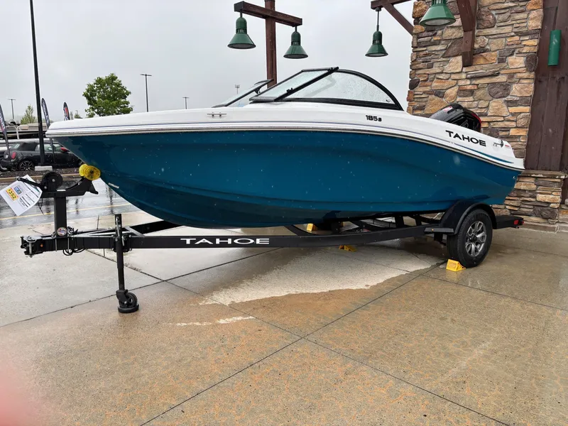 The Image of 2025 Tahoe 185 S boat on trailer, blue hull, parked outdoors. - 0