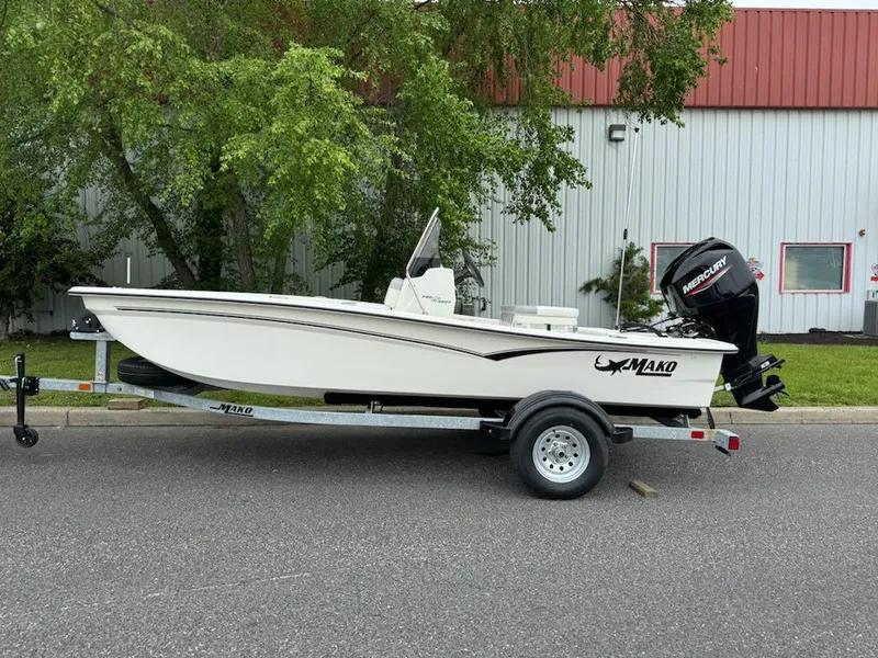 Slide: The Image of 2025 Mako Pro Skiff 15 CC boat on trailer, parked outdoors. - 1
