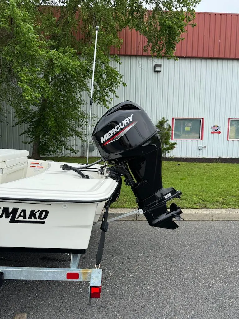 Slide: The Image of 2025 Mako Pro Skiff 15 CC with Mercury outboard motor, parked outdoors. - 5