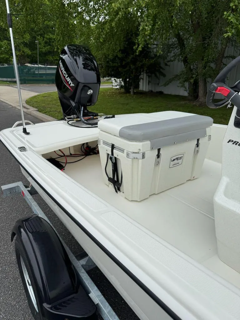 Slide: The Image of 2025 Mako Pro Skiff 15 CC boat with motor and cooler on trailer. - 6
