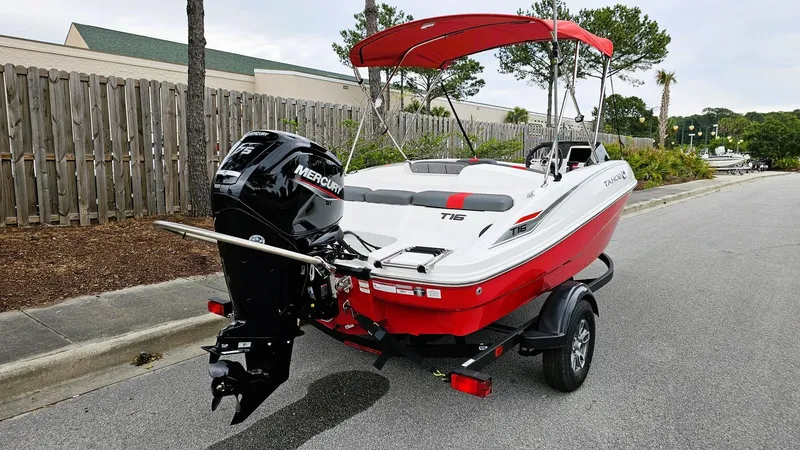 Slide: The Image of 2025 Tahoe T16 boat with Mercury engine on trailer, parked on a street. - 2