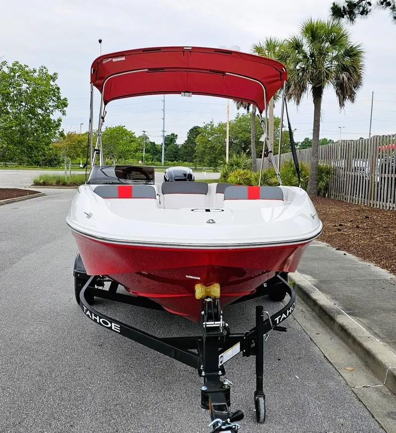 Slide: The Image of 2025 Tahoe T16 boat with red canopy on trailer, parked outdoors. - 5