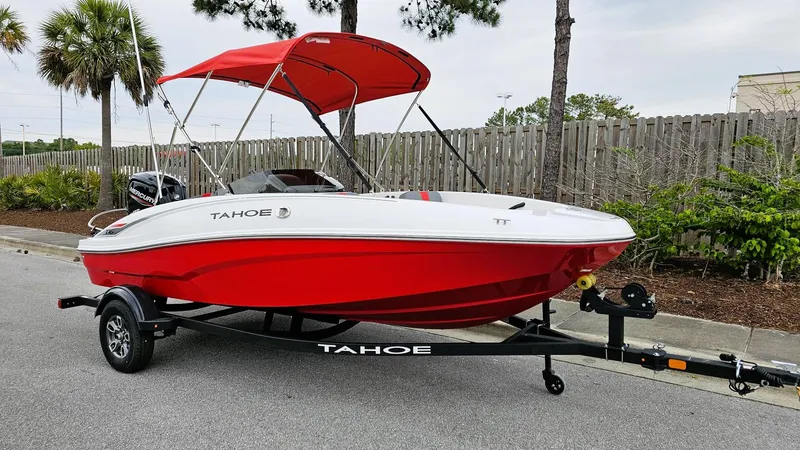 Slide: The Image of 2025 Tahoe T16 boat with red and white design on a trailer, parked outdoors. - 6