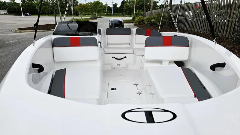 Slide: The Image of 2025 Tahoe T16 boat interior with white and red seating, parked outdoors. - 8