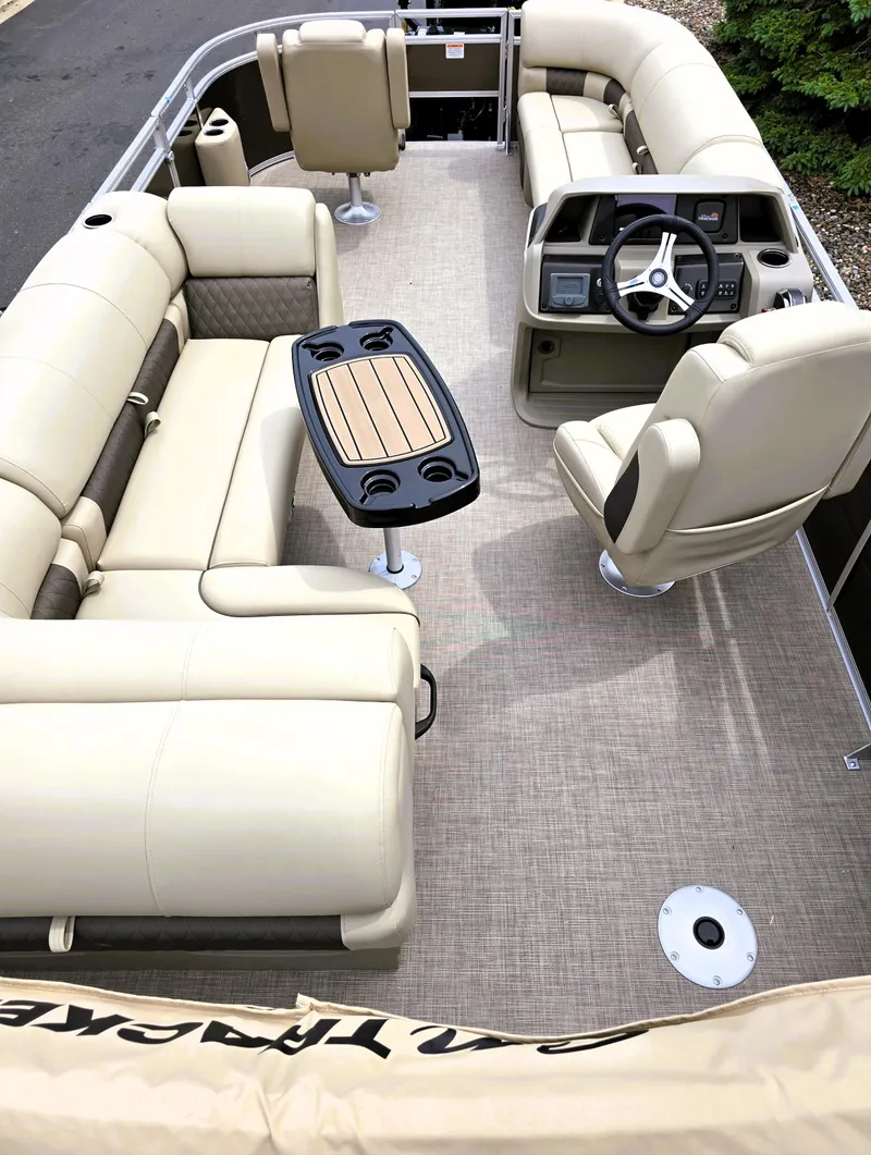 Slide: The Image of 2025 Sun Tracker SportFish 20 DLX pontoon boat interior with beige seating and steering console. - 3