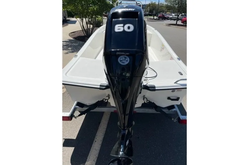 Slide: The Image of 2025 Mako Pro Skiff 15 CC with Mercury 60 outboard engine, parked on trailer. - 2
