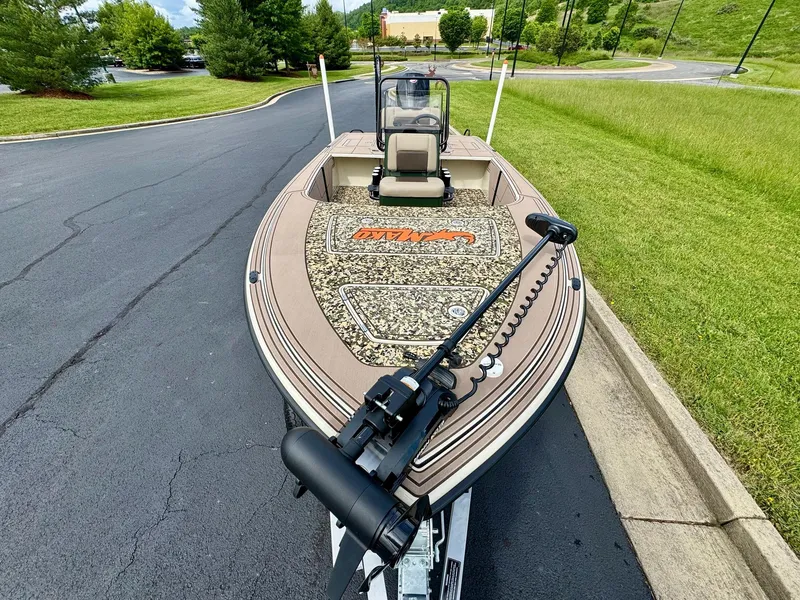 Slide: The Image of 2025 Mako 18 Pro Skiff Backwater Edition on a paved road, surrounded by greenery. - 2
