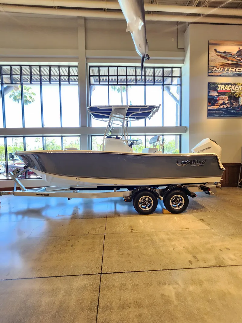 The Image of 2025 Mako 214 CC boat on trailer in showroom, side view. - 0