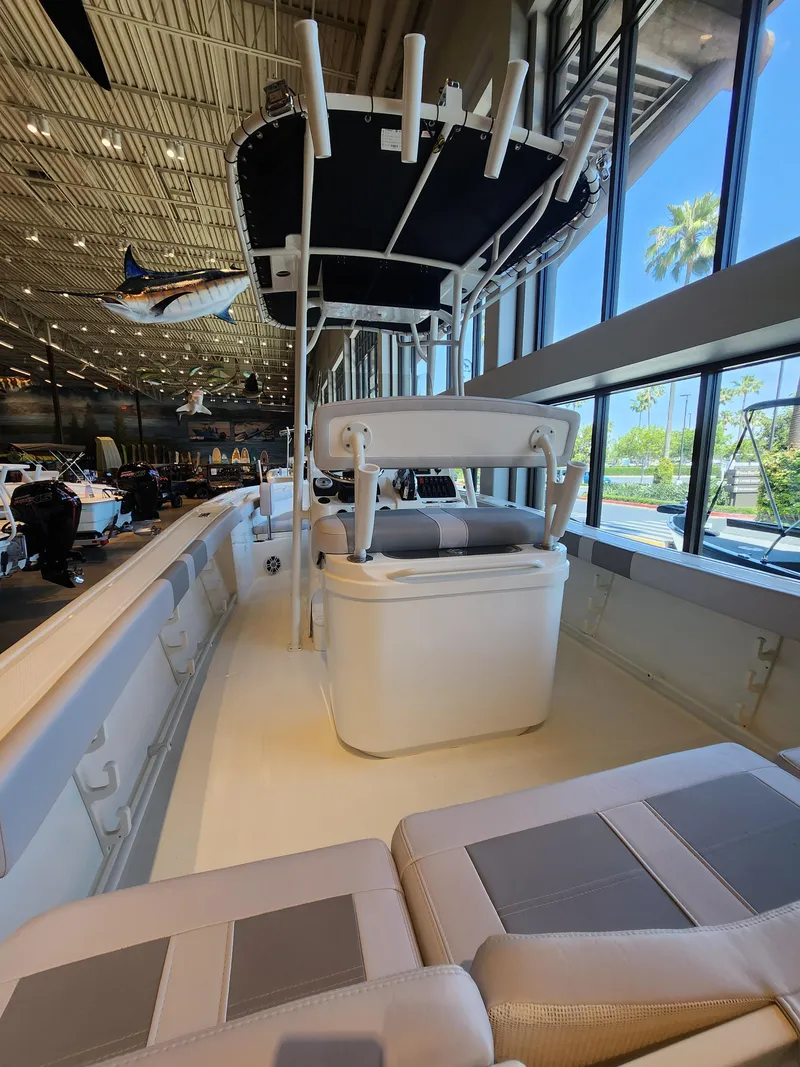 Slide: The Image of 2025 Mako 214 CC boat interior with seating and canopy, displayed indoors. - 3