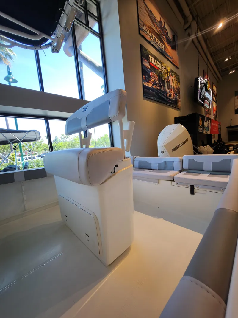 Slide: The Image of 2025 Mako 214 CC boat interior with seating, displayed in a showroom setting. - 4